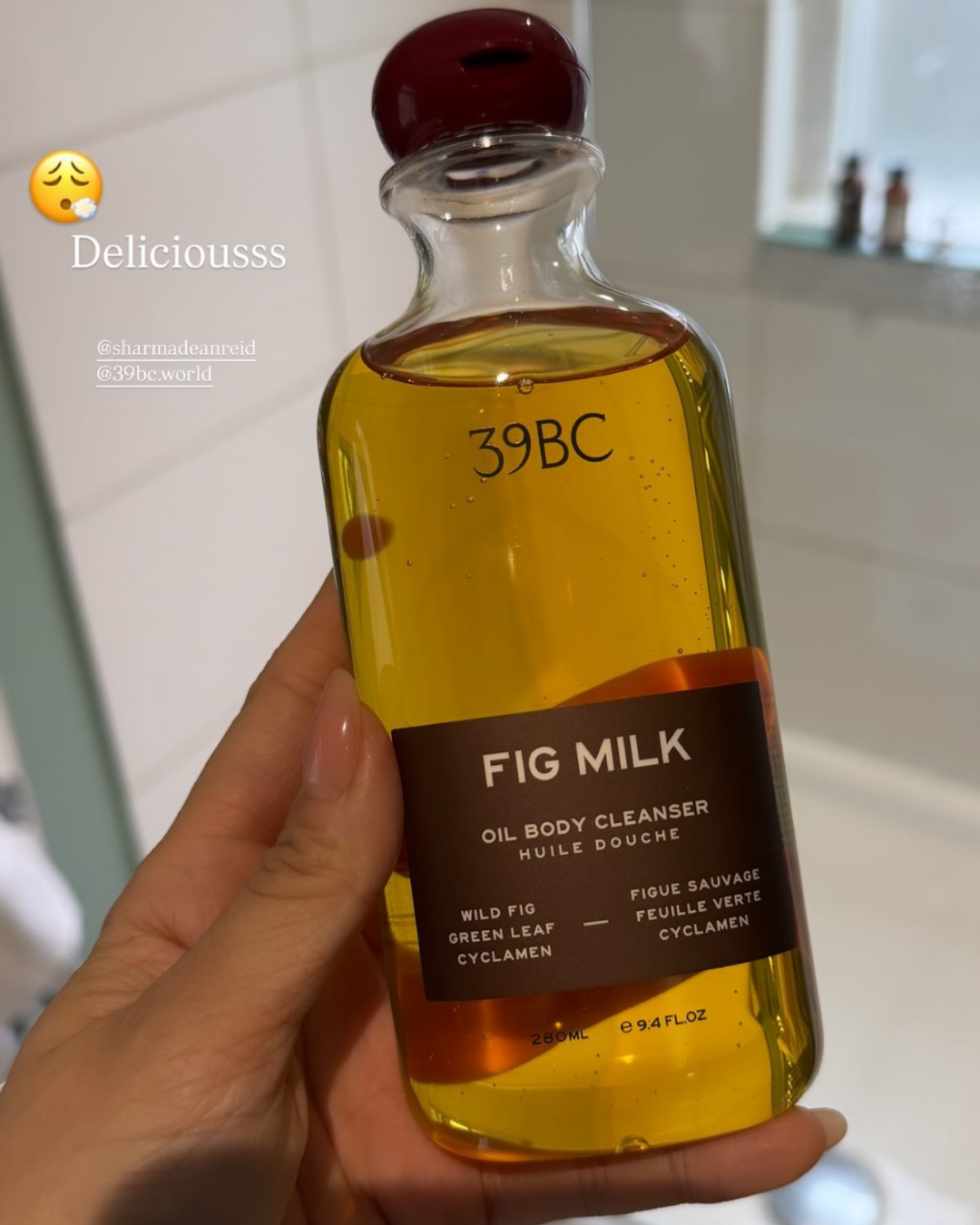 Hand holding a bottle of 39BC Fig Milk Bath & Shower Oil