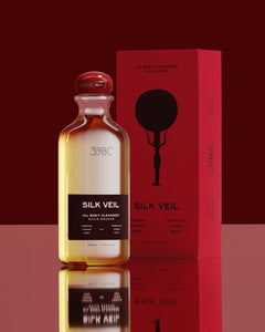 Bottle of 39BC Silk Veil oil body cleanser with red packaging on a reflective surface.